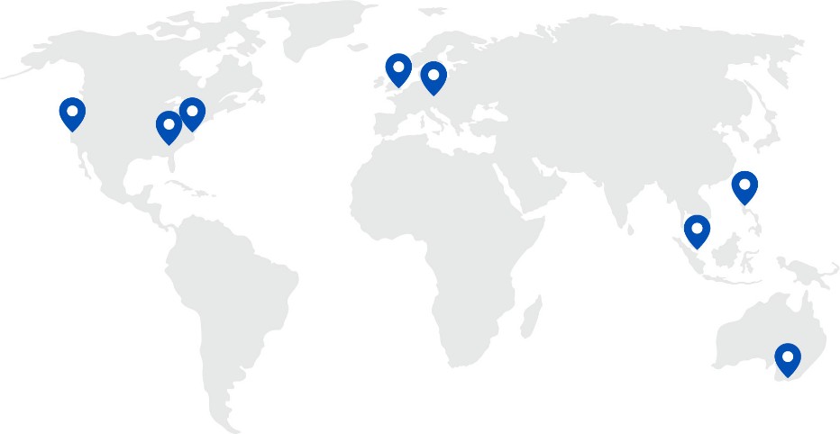 World map with light grey continents with blue pins showing office locations on map